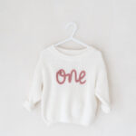 Over-sized one jumper part of the studio wardrobe for first birthday photoshoots.