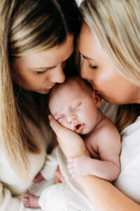 new parents kissing baby on their natural baby photoshoot near Wilmslow