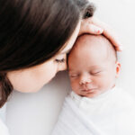 Mother with her newborn baby on a newborn photoshoot