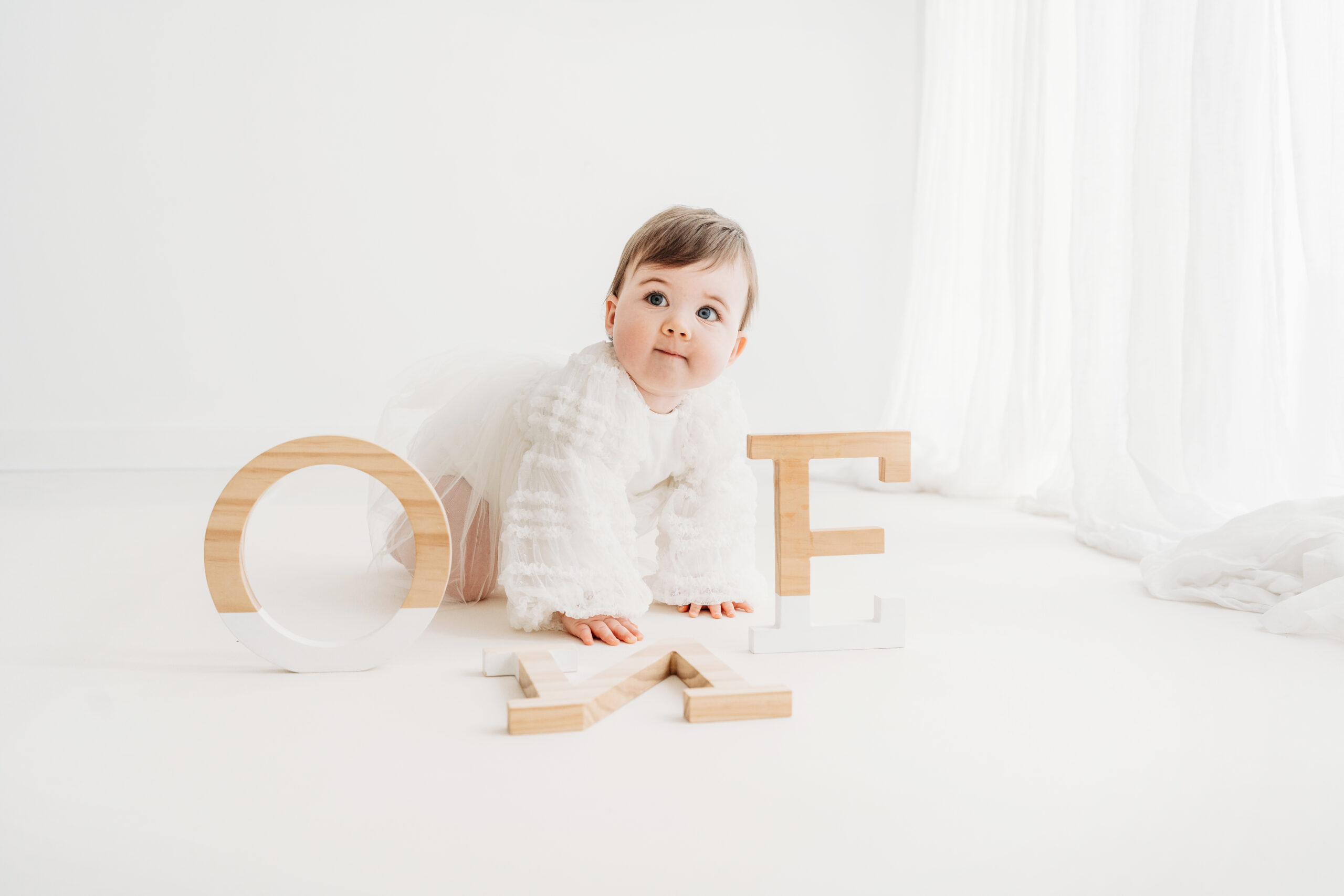 Beautiful baby girl with ONE letters on her first birthday photoshoot