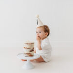 Baby boy eating cake on natural cake smash in Cheshire