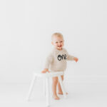 Baby girl turning one on her cake smash in cheshire in natural all white photography studio