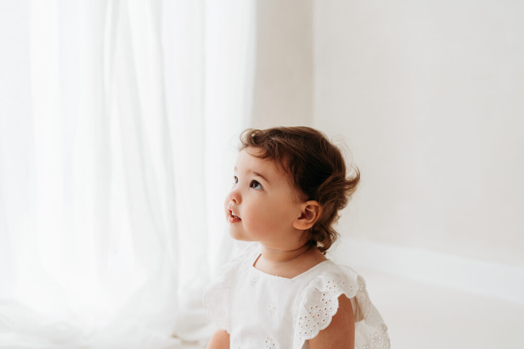 Little toddler looking up to her mother on her natural toddler photoshoot in Cheshire