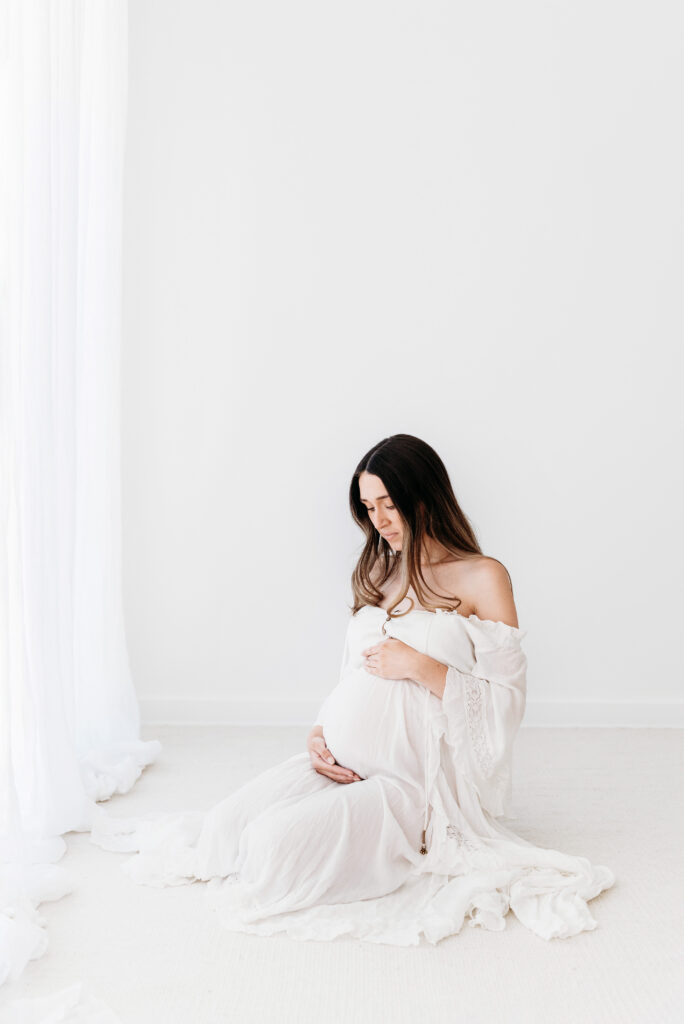 Pregnant mother kneeling down on her maternity photoshoot in Cheshire