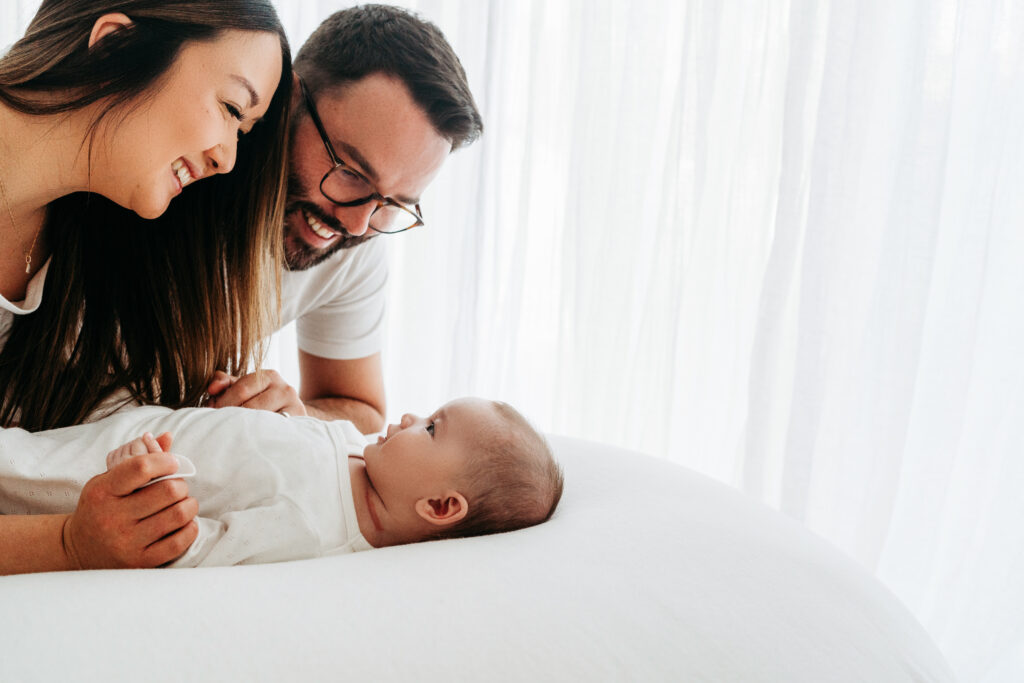 Parents looking down at their baby on a family photoshoot in Cheshire.