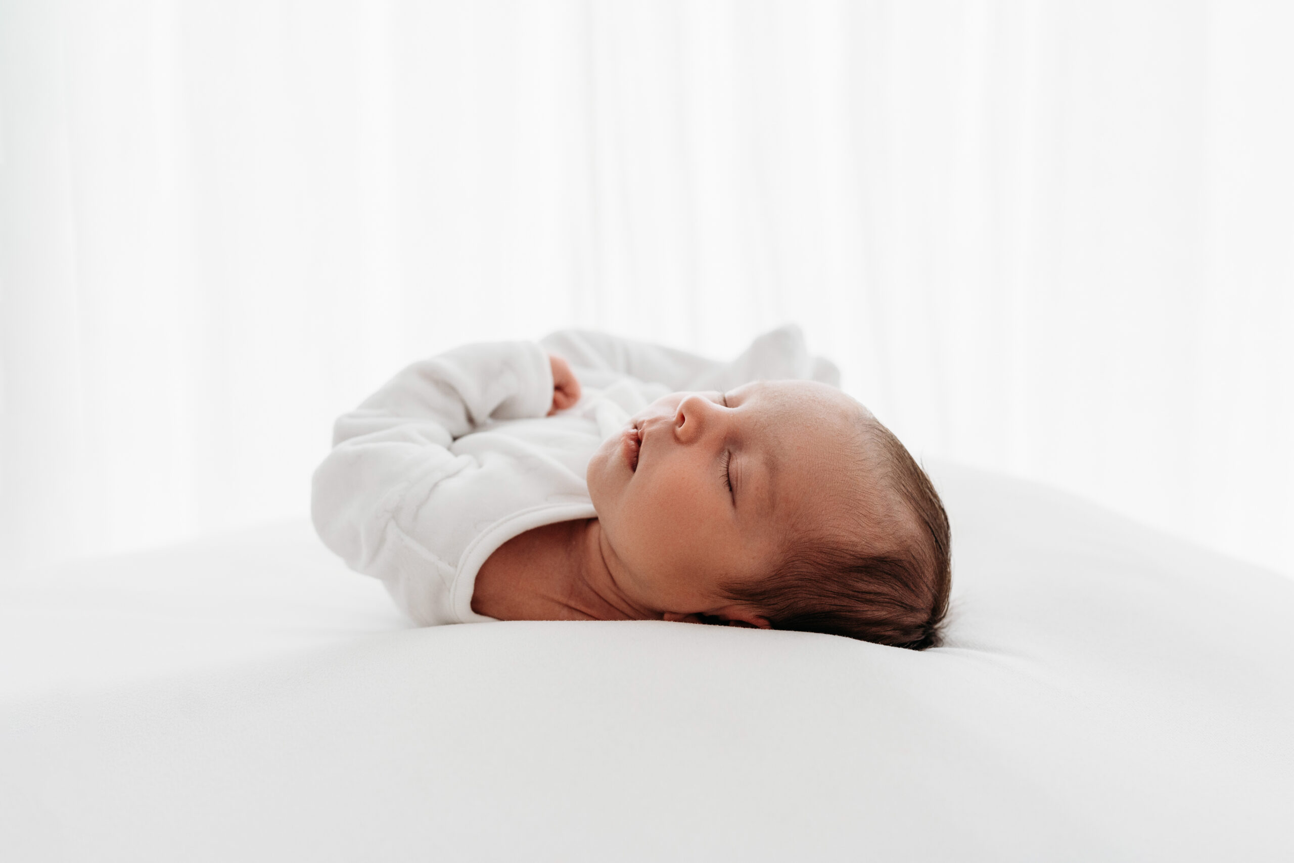 Baby lying on white blanket on a beanbag for a photoshoot