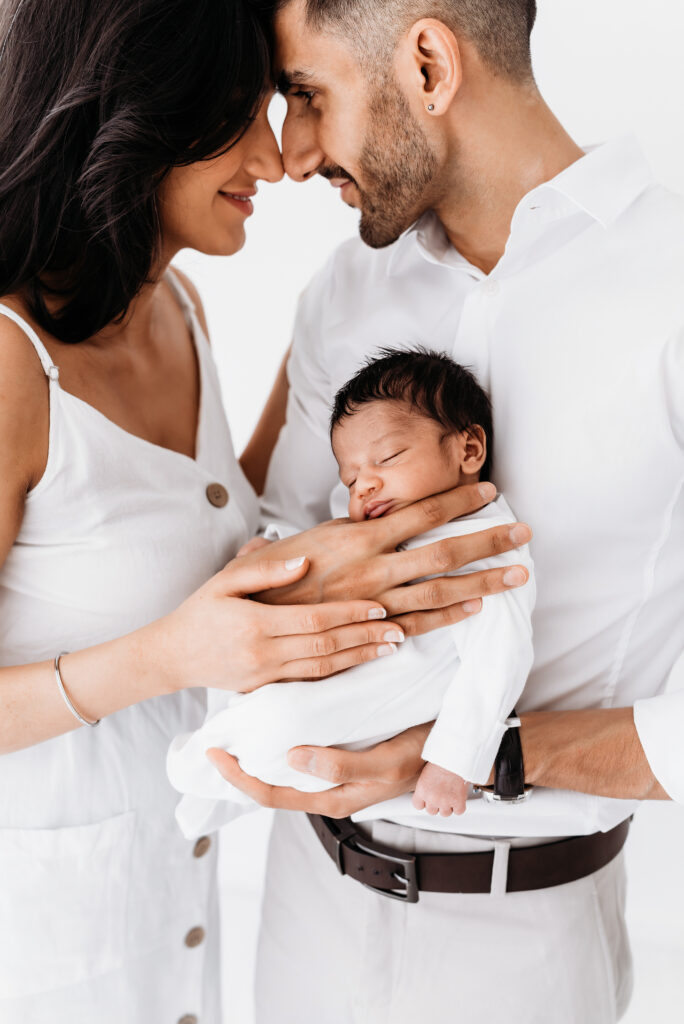 Image of new parents cuddling their baby on a newborn photography  training day